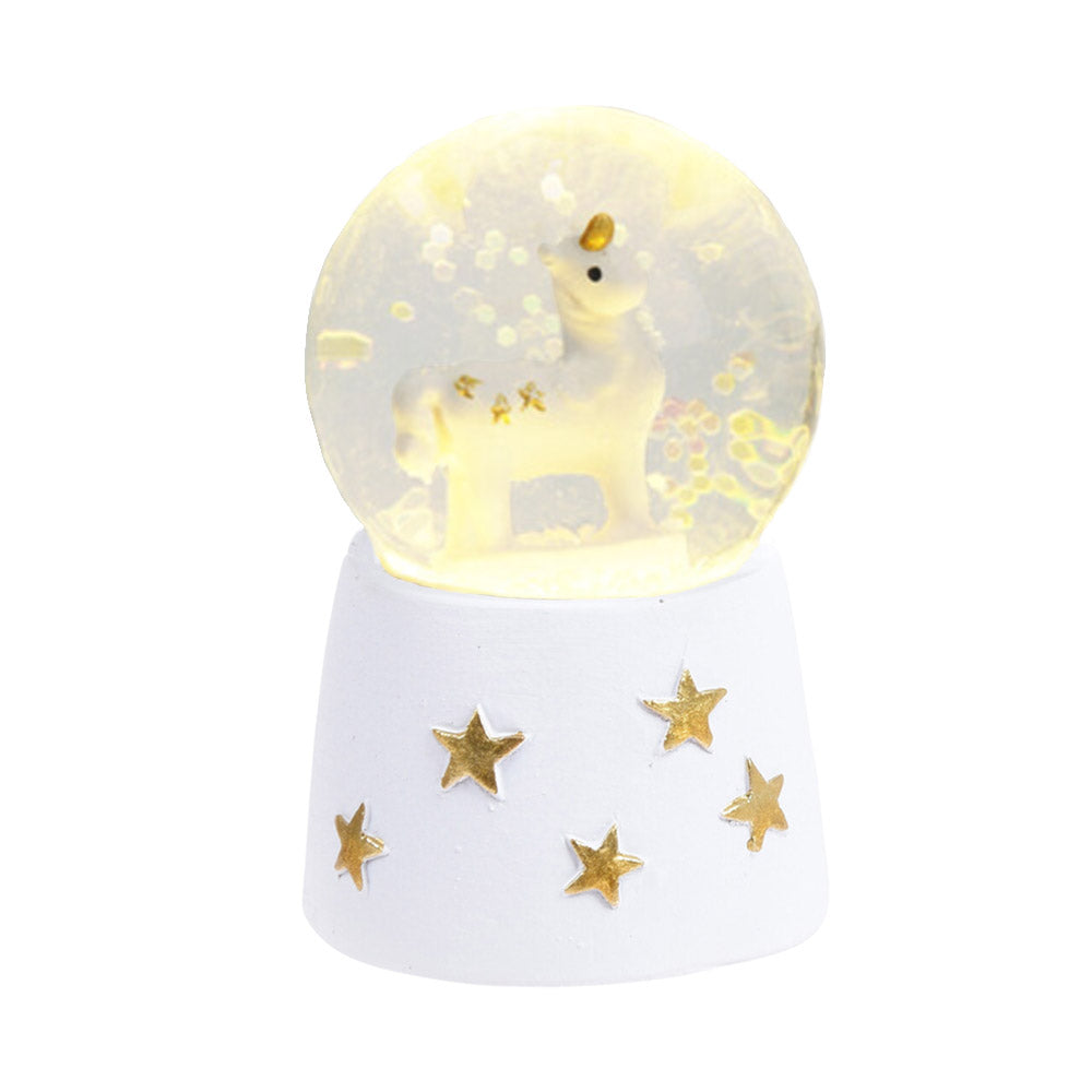 Bola de agua con forma de bola de nieve con unicornio sobre base blanca con estrellas doradas y LED blanco cálido